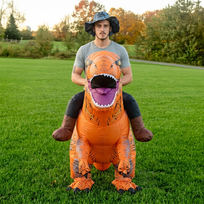 Front view of adult riding blow up dinosaur costume, showing T-Rex mouth, small arms and faux boots