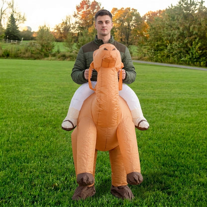 Front view of tan blow up camel costume with long neck and faux rider legs in white pants and shoes