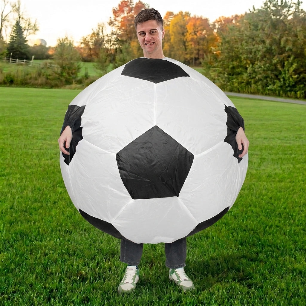 Front view of black and white blow up soccer ball costume worn over the torso on green grass