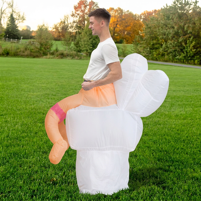 Side profile of inflatable toilet costume with raised lid and tank, worn by adult in a grass field