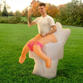 Three quarter view of adult in inflatable toilet costume waving, white toilet with faux legs in pink briefs