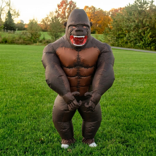 Front view of inflatable gorilla costume with sculpted brown chest and red open mouth on green grass