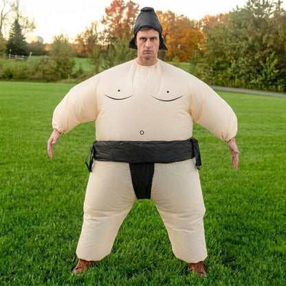 Front view of adult in inflatable sumo wrestler costume with arms out, black belt and topknot hair