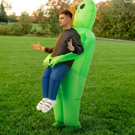 Side profile of green inflatable alien abduction costume worn outdoors with faux legs and white sneakers