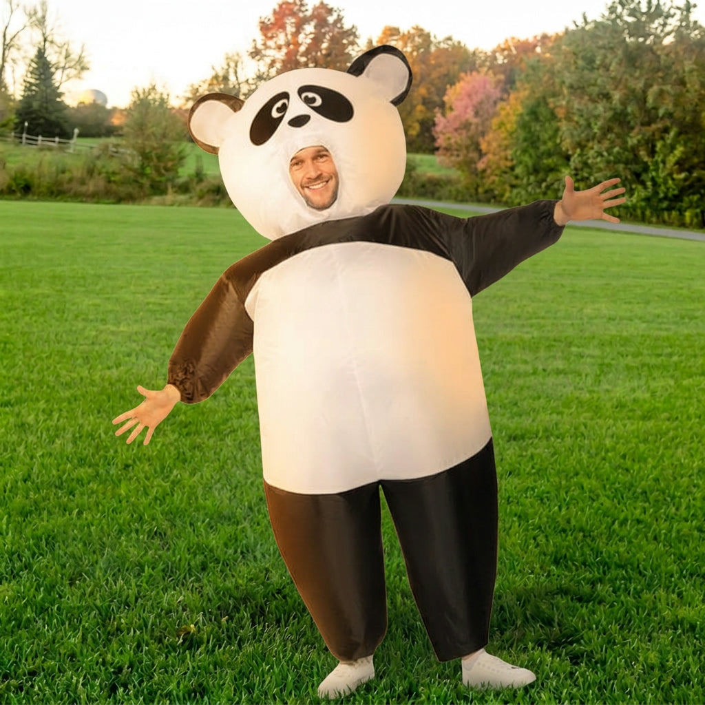 Three quarter view of black and white blow up panda costume with arms spread wide on green grass